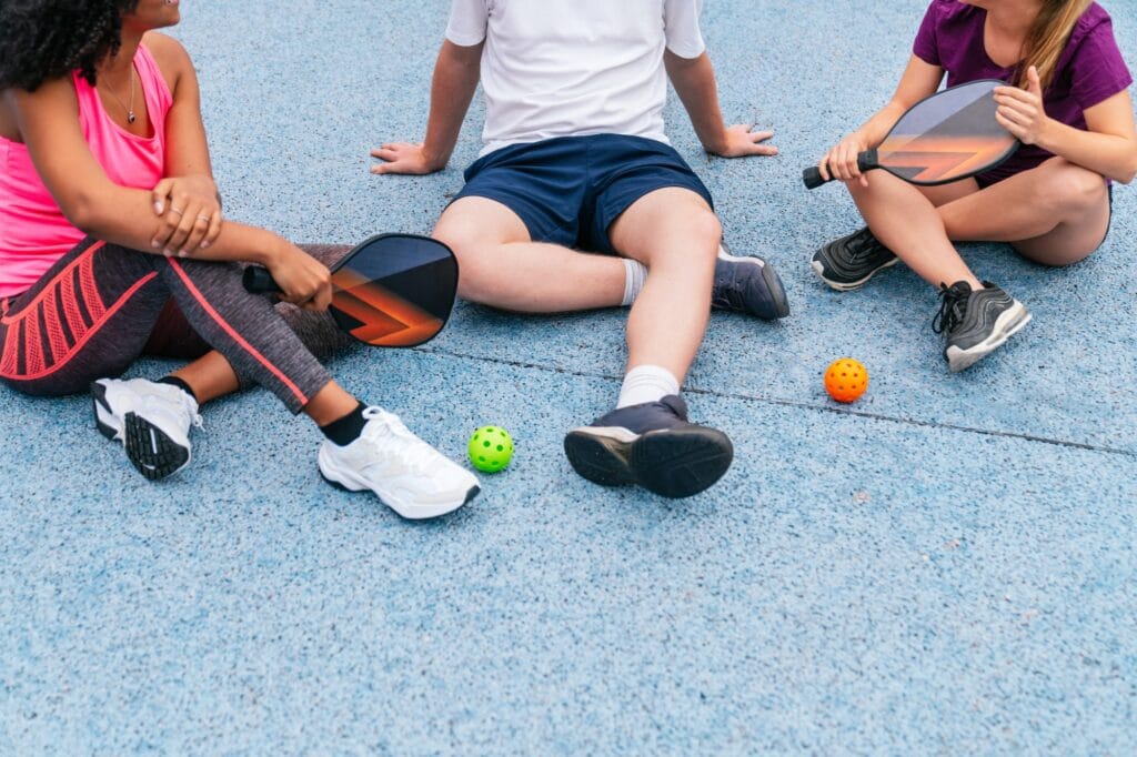 Home 31 Multiethnic athletes resting after playing pickleball outdoors